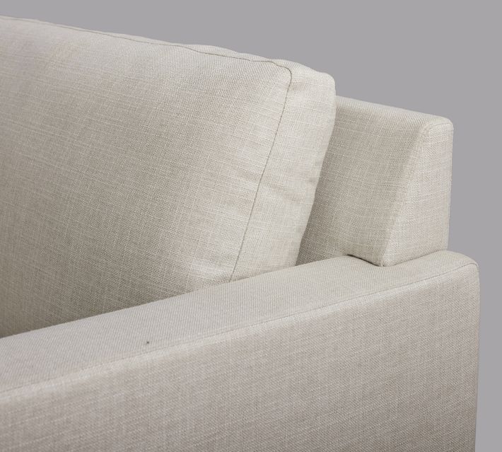 Front corner of sofa showing armrest and base seam