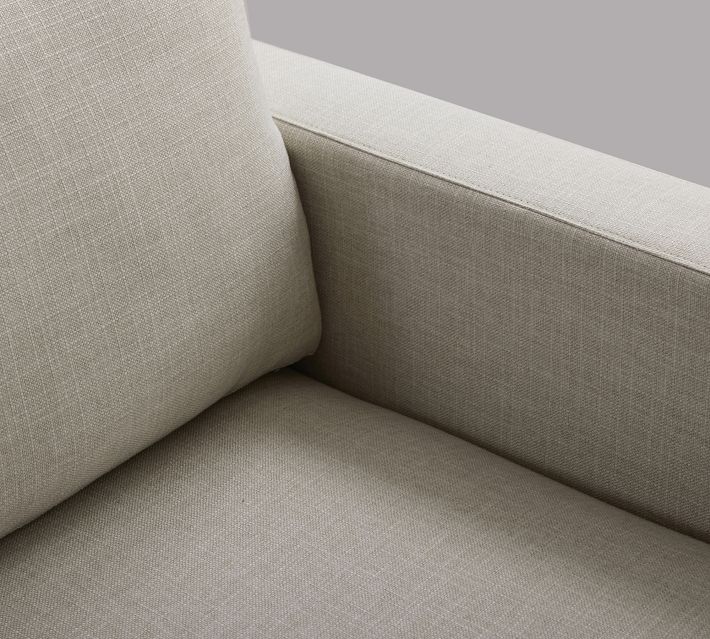 Close-up of beige upholstery on the sofa arm and armrest