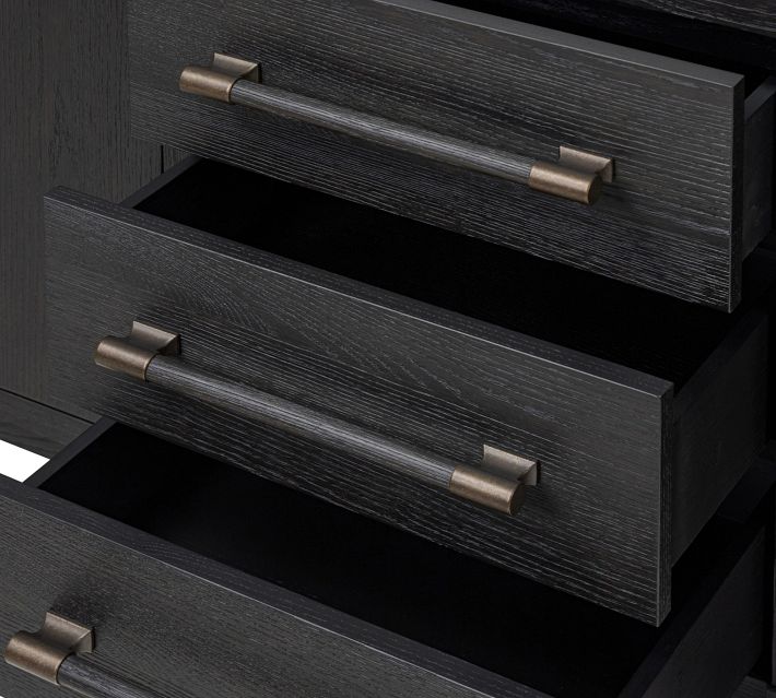 Open drawer showing interior compartment and hardware on a dark wood dresser