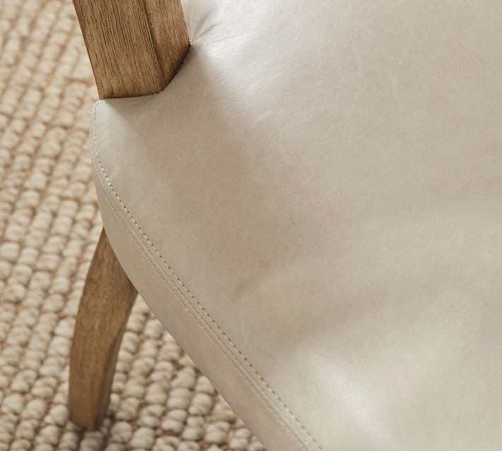 Beige upholstered chair seat and armrest detail