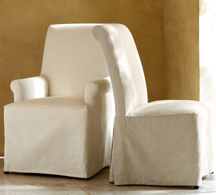 White upholstered dining chair with rolled arm cushions visible
