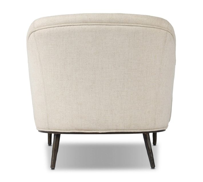 Rear view of beige upholstered chair showing curved back and dark wooden legs