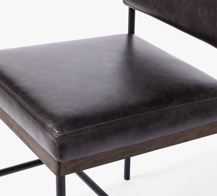Close-up of seat edge and stitching on black leather chair.
