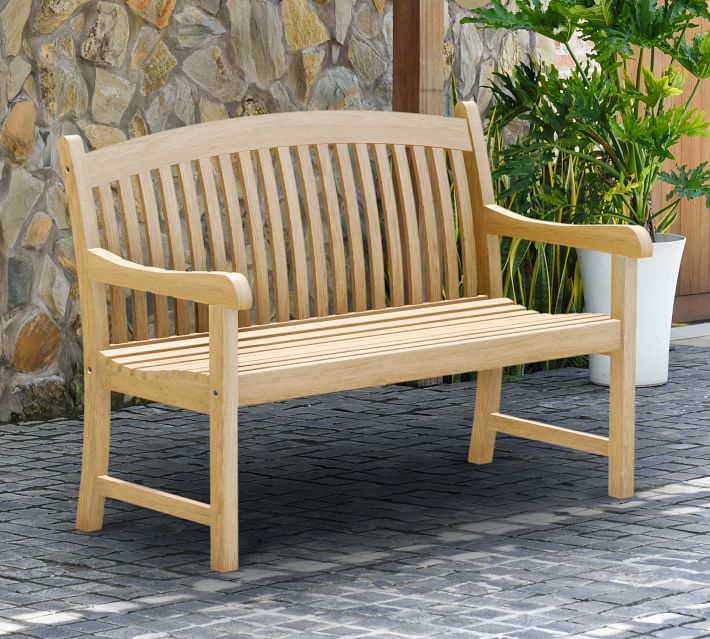 A wooden outdoor bench with slatted back and seat, curved armrests, and sturdy legs.