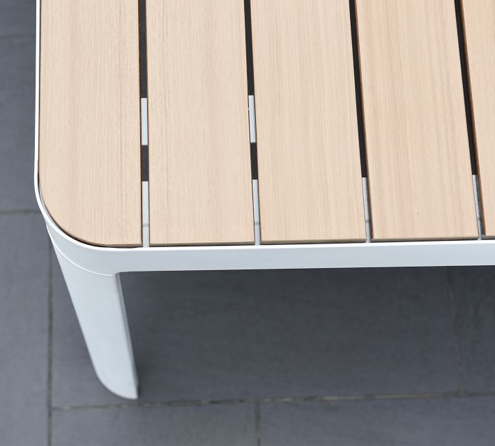Close-up corner of the table showing rounded edge and slats, white frame