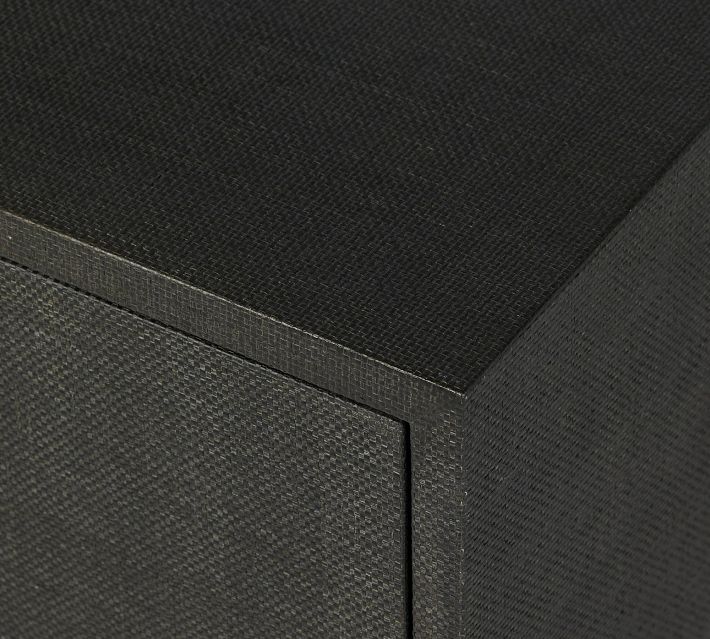 Top edge of a dark textured cabinet with fabric-like finish.