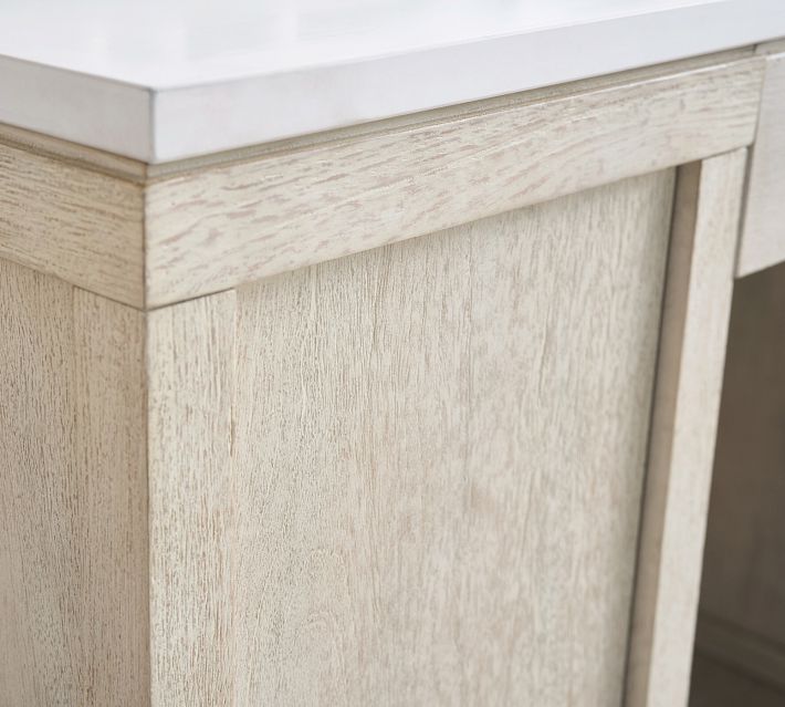 Close-up of the light wood vanity paneling with a white countertop edge.