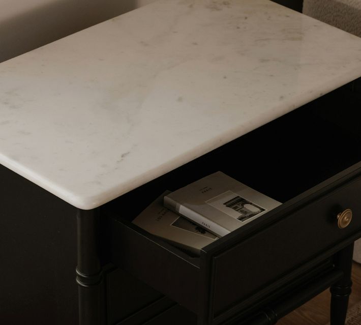Open drawer showing interior of nightstand with items inside.
