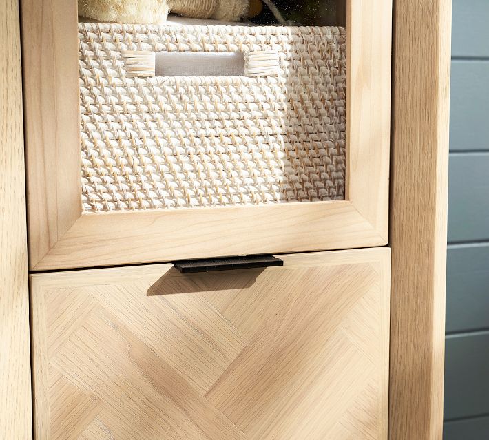 Close-up of woven basket storage inside a wooden cabinet drawer, showing the textured basket and frame.