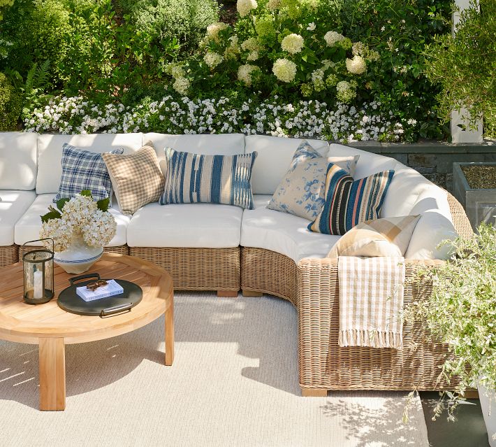 White cushioned sectional sofa with colorful patterned throw pillows.