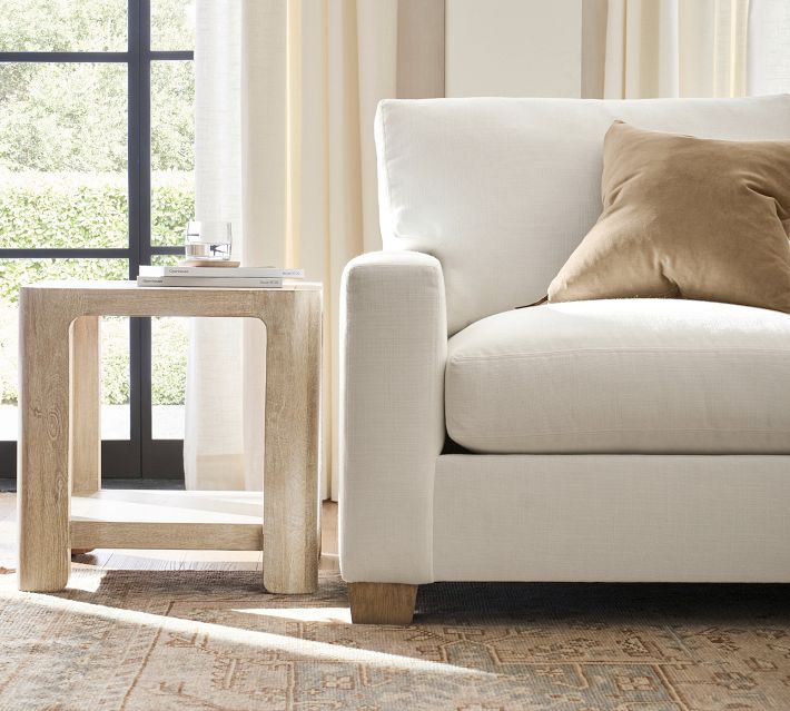 Close-up of light sofa arm and leg on hardwood floor