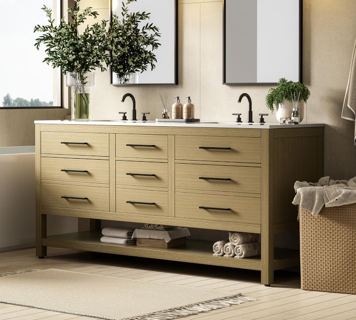 A wooden bathroom vanity with three columns of drawers and an open lower shelf, two sinks, and a tidy, modern look.