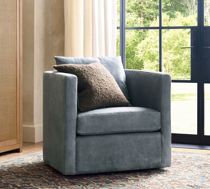 Blue velvet armchair with pillow in bright room