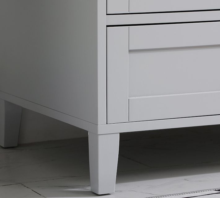 Lower corner of a light gray bathroom vanity showing leg and base