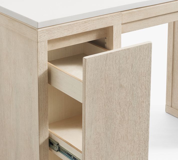 Open cabinet with a small drawer inside of the light wood vanity.