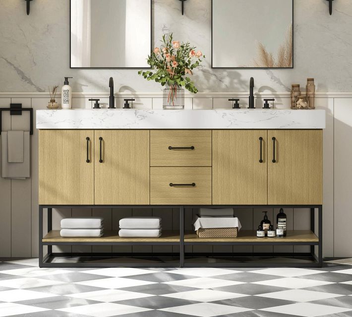 A close-up of the same bathroom vanity showing the cabinet doors, drawers, and open shelf with towel storage.