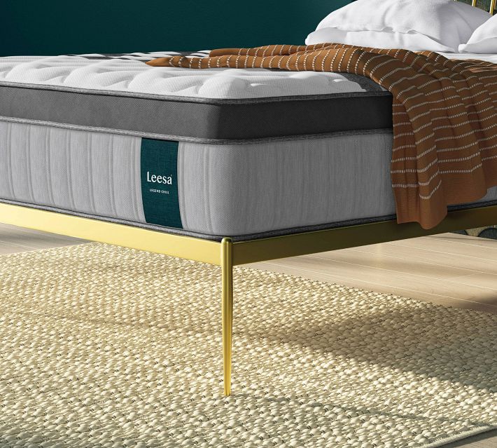 Close-up of Leesa mattress with teal tag on the side and brown blanket on top