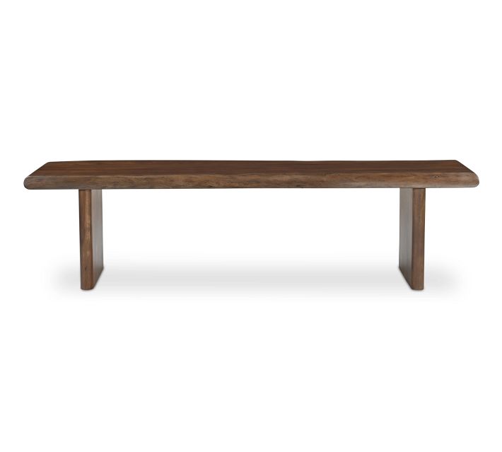 Full view of the bench from the side with two legs supporting a long wooden top.
