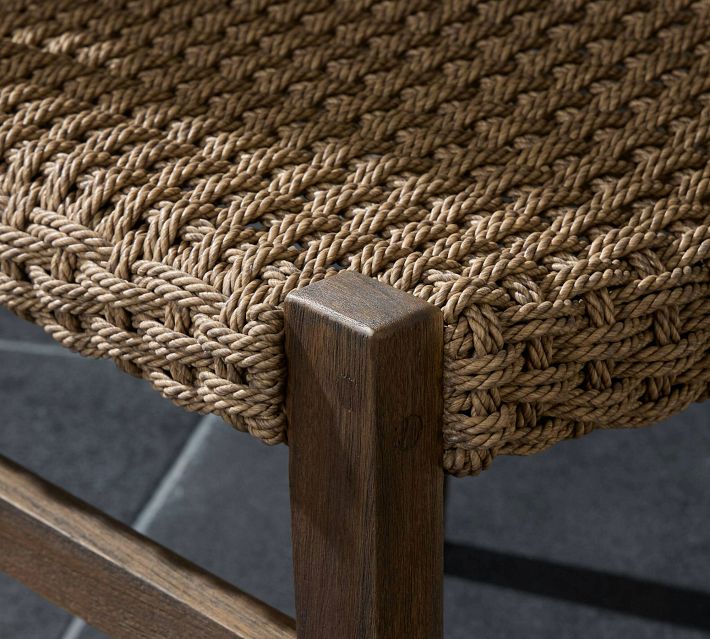 Close-up of woven rattan chair corner showing the thick braided weave and wooden leg