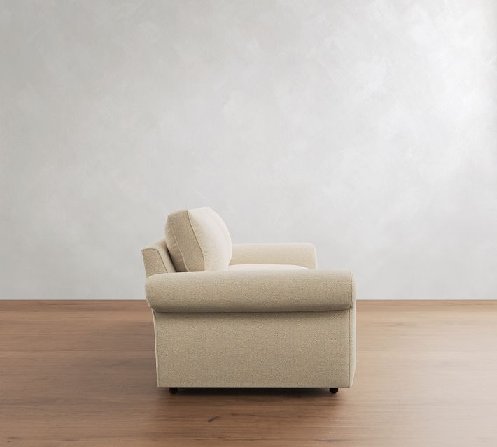 Beige loveseat in profile view showing side cushions and armrest.