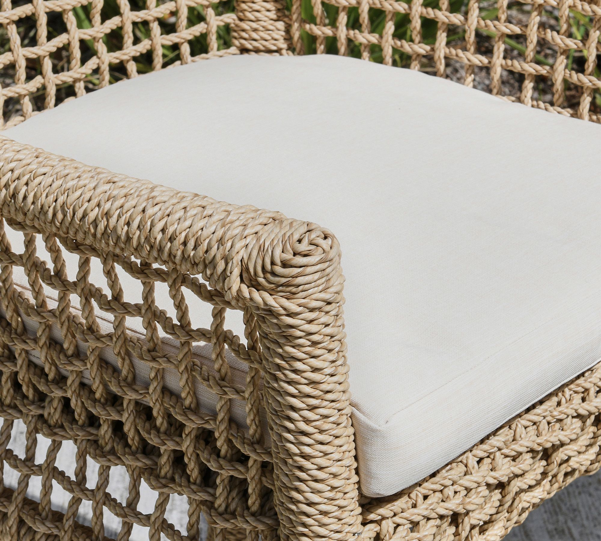 Close-up of the woven edge and cushion on the arm of the stool