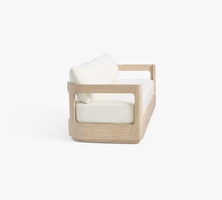 Side view of a wooden armchair with white cushions