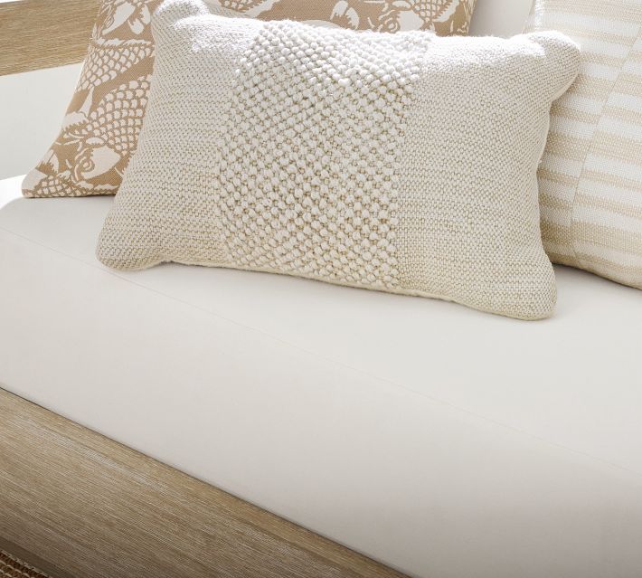 Close-up of a textured beige decorative pillow on a white cushion