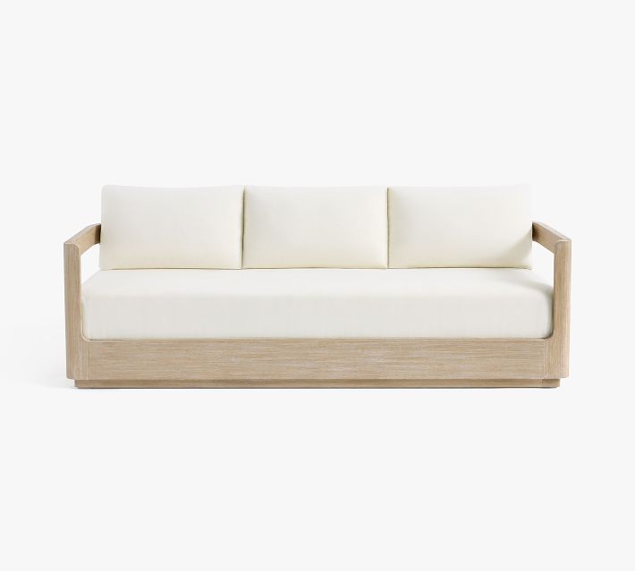 A white three-seater sofa with wooden frame and three back cushions