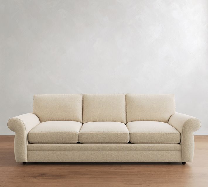 Beige three-seat sofa with three back cushions and rolled arms.