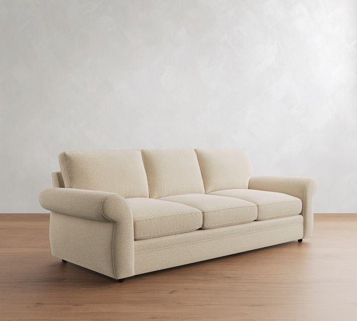 Beige three-seat sofa with three plush back cushions.