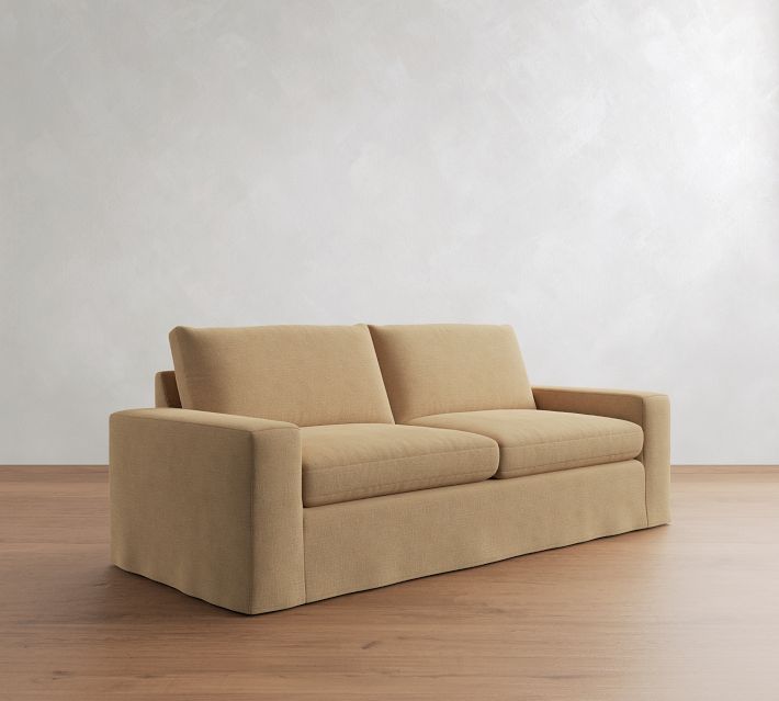 Beige sofa with two seat cushions, three back cushions, and exposed arms