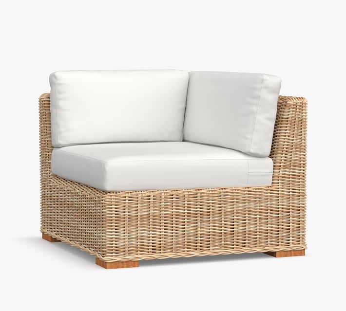 Product image: corner wicker sofa with light cushions.