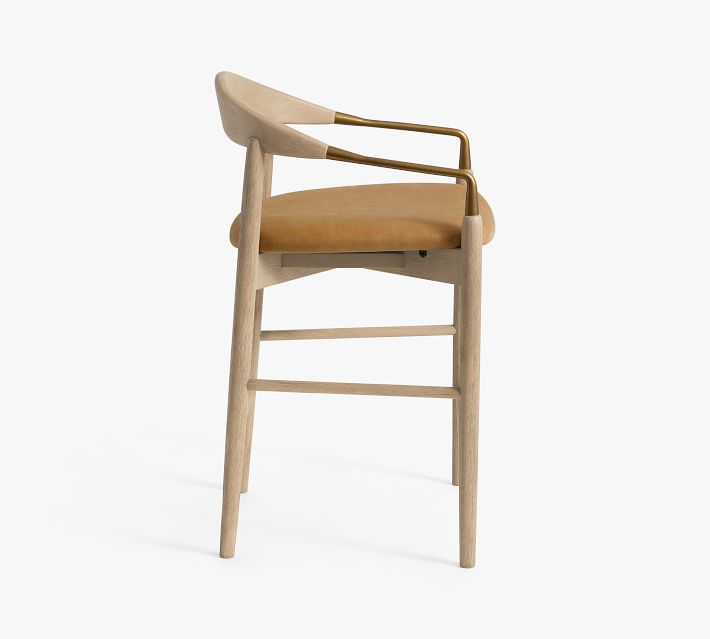 Side view of bar stool focusing on armrest and brass accent