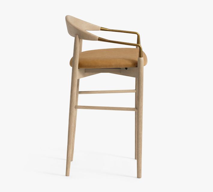 Side-front view of tall bar stool with brass armrest