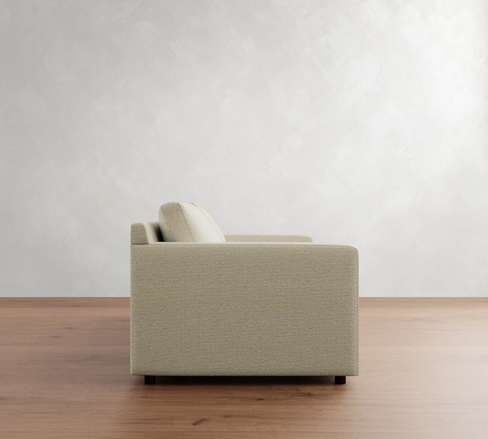 Side view of the beige fabric sofa highlighting its right side, with two back cushions visible.
