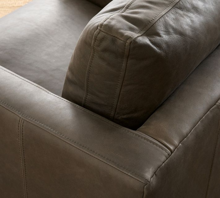 Close-up of the armchair’s corner showing stitching and seam details on the dark brown upholstery.