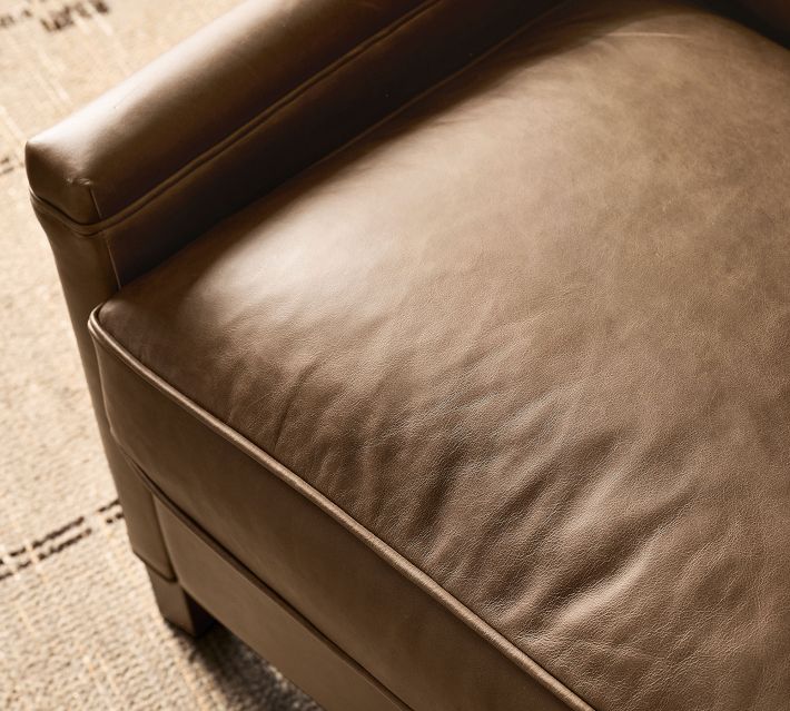 Close-up of the leather armrest and seam on the brown recliner.