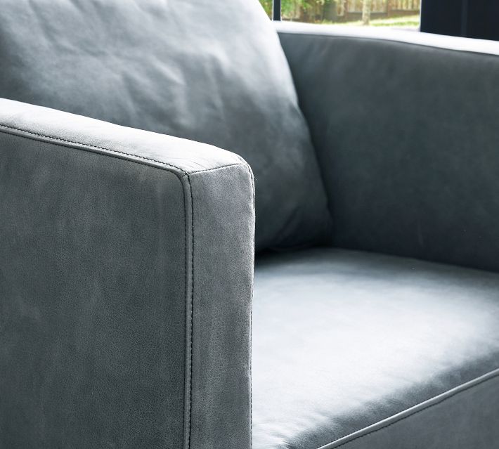Close-up of blue velvet armchair arm with visible stitching