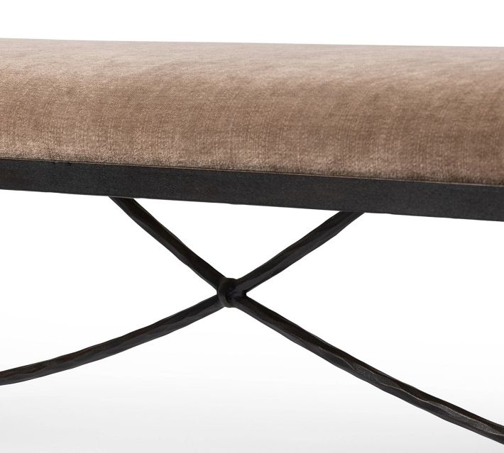 Lower side view of bench showing the curved metal cross brace and upholstered edge above.