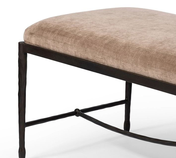 Close-up of the bench leg and the side rail, focusing on the dark textured metal and the cushion edge.