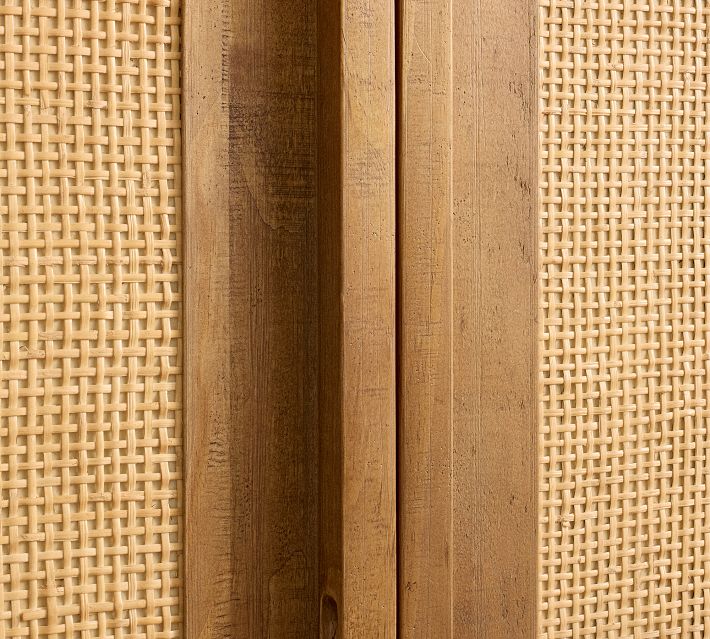 Close-up of woven panels and wooden frame detail on cabinet door edge.