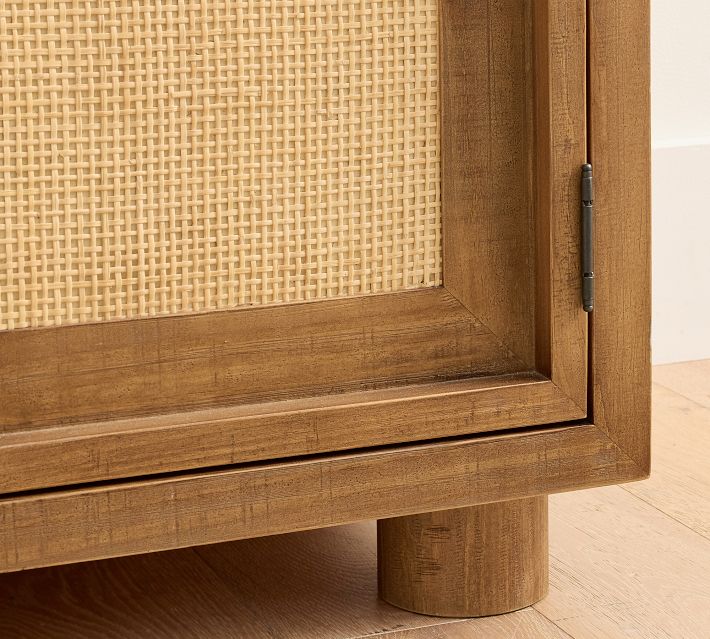 Bottom corner of cabinet showing woven panel and wooden leg.