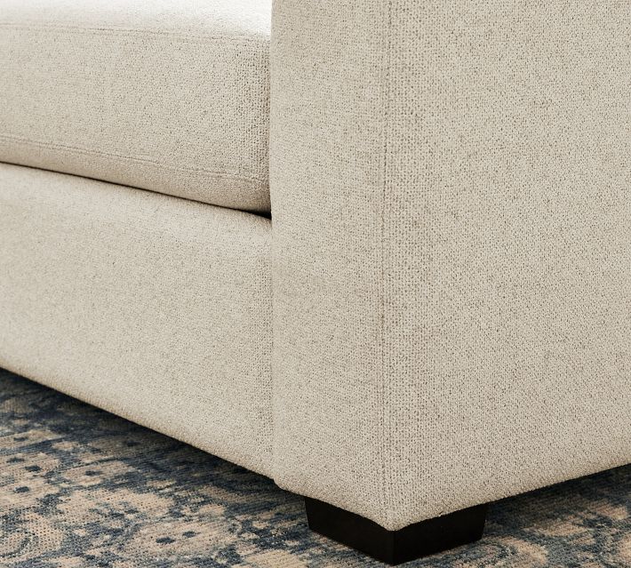 Corner of armrest and base of sofa showing leg