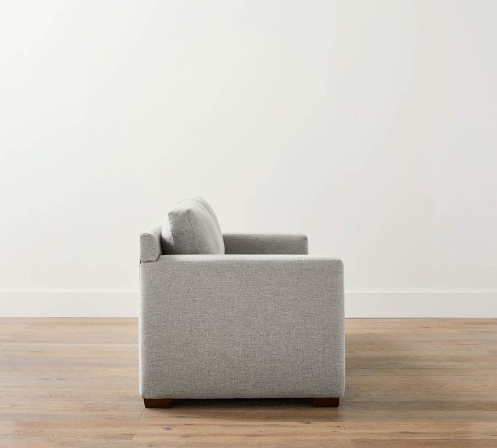 Profile view of single gray fabric sofa showing side with armrest and back cushion