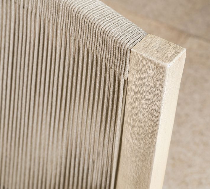 Close-up edge and corner of rope-wrapped armchair showing tightly woven strands and wooden frame.