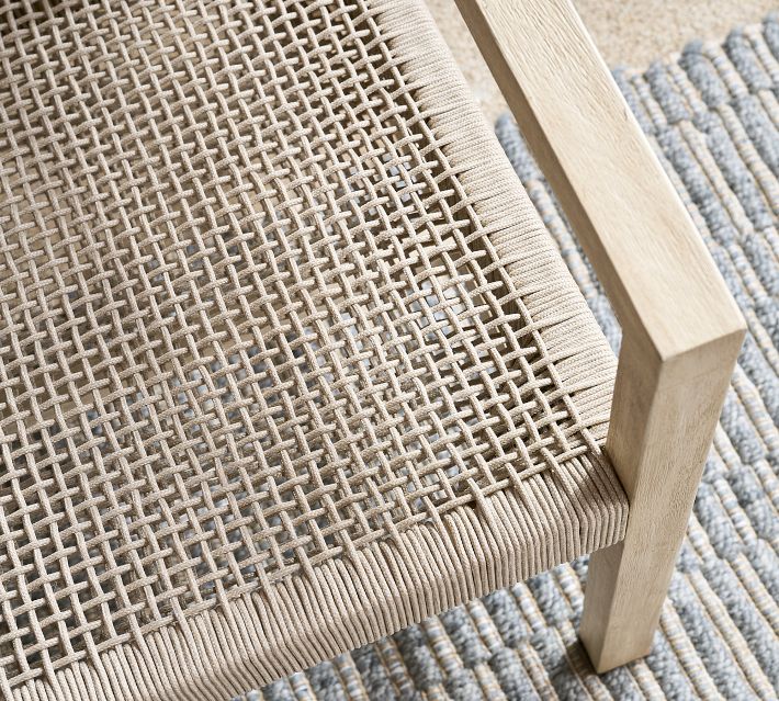 Corner of woven outdoor chair seat with vertical and horizontal cords in a tight grid pattern.