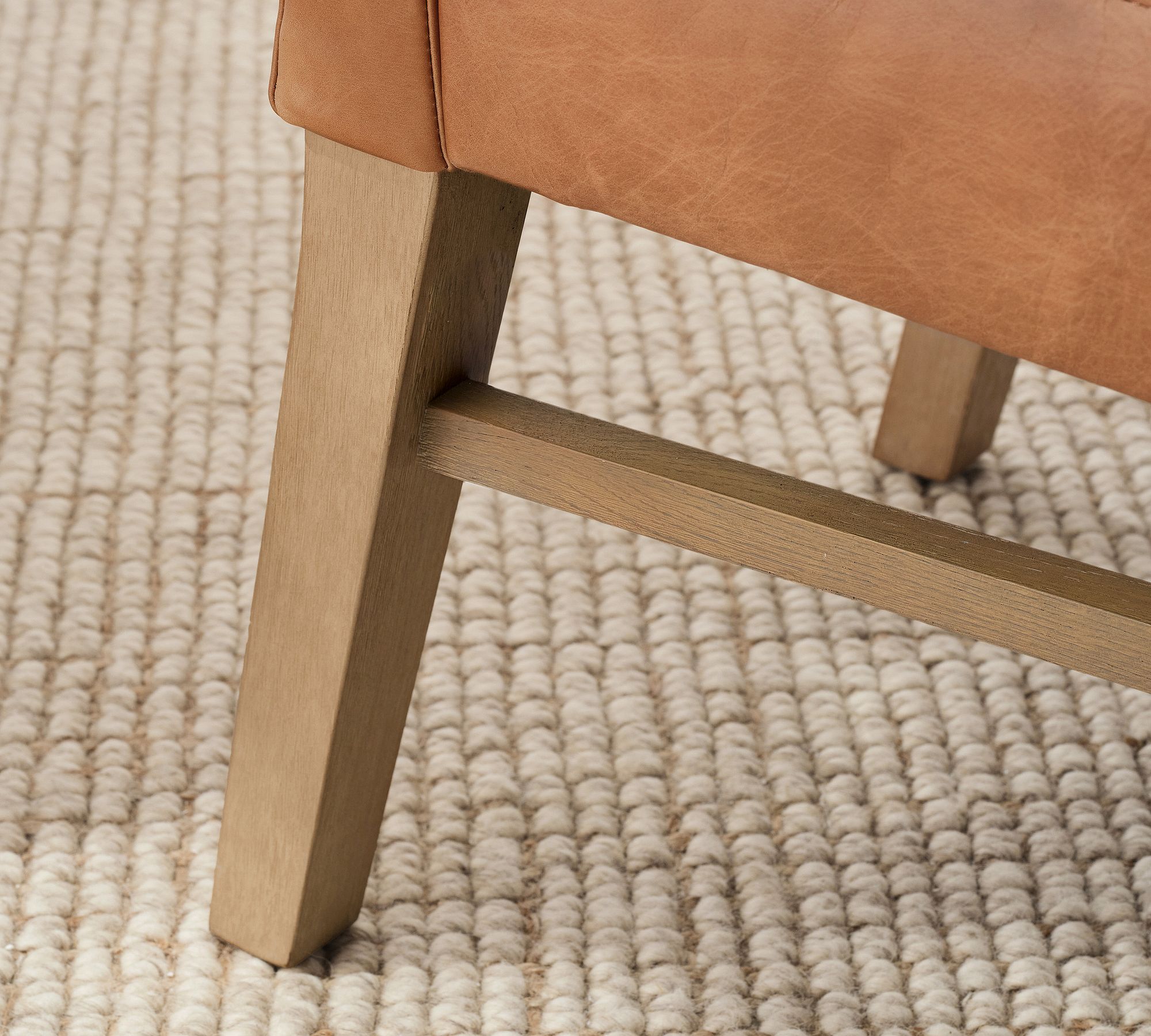 Chair leg and lower frame detail with woven rug